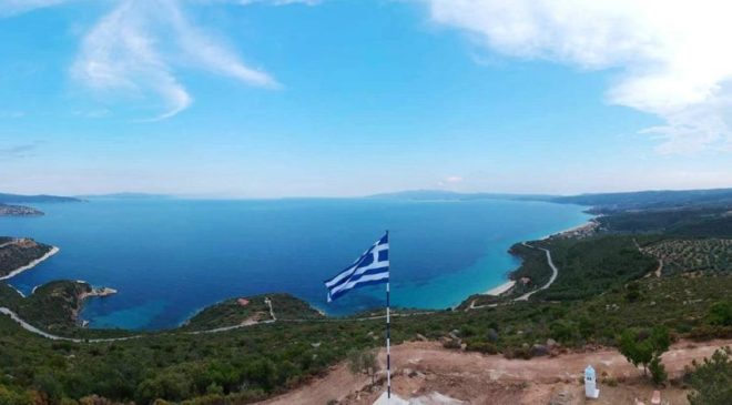 Η ελληνική σημαία που κυματίζει στη Χαλκιδική με θέα το απέραντο γαλάζιο (ΒΙΝΤΕΟ & ΦΩΤΟ)